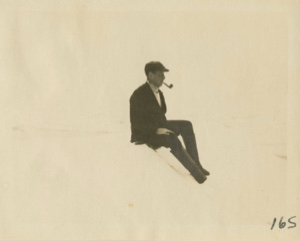 Image of Man with pipe sitting on snow bank